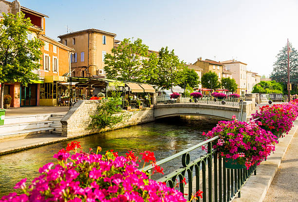 Row of restaurants and houses by the Sorgue river - border of L'Isle-sur-la-Sorgue old town (Provence, France).